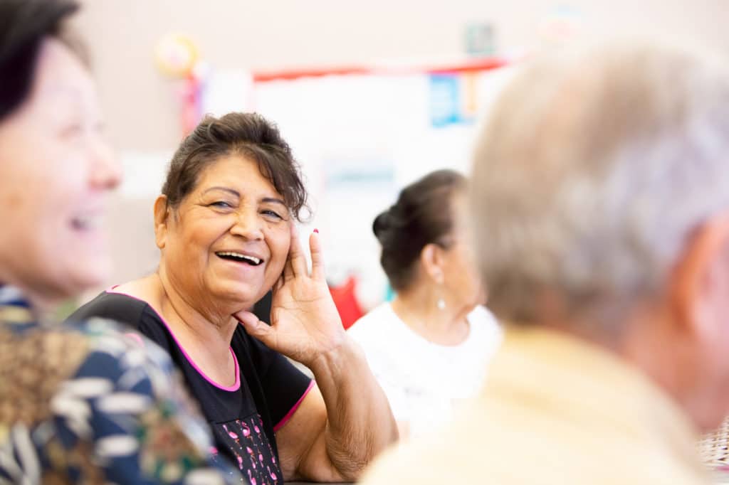 Smiling Hispanic Woman in a Senior Activity Center